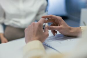 Close-up of hands holding a pen during a business meeting or contract signing.